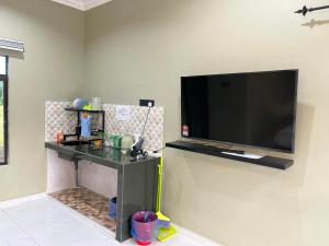 a flat screen tv hanging on a wall at Rumah Armand Studio Family Suite with Swimming Pool Pengkalan Balak Tg Bidara Masjid Tanah Melaka 