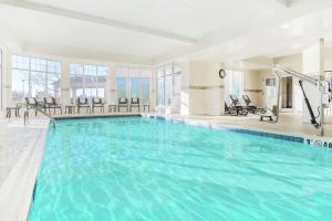 a large swimming pool with blue water in a building at Hilton Garden Inn Roanoke Rapids in Roanoke Rapids