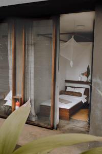1 dormitorio con 1 cama y 1 sombrilla en Kaliwa Lodge, en Moshi