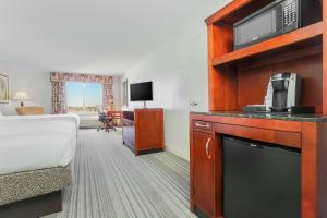 a hotel room with a bed and a television at Hilton Garden Inn Roanoke Rapids in Roanoke Rapids