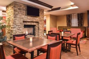 a restaurant with tables and chairs and a fireplace at Hampton Inn Statesville in Statesville