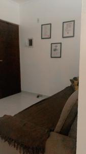 een bed in een kamer met drie foto's aan de muur bij Apto confortável in Solemar
