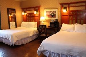 a hotel room with two beds and a desk at Glen Tavern Inn in Santa Paula