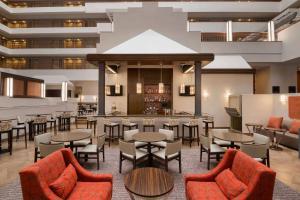 a restaurant with tables and chairs and a bar at Embassy Suites by Hilton Baltimore at BWI Airport in Linthicum Heights