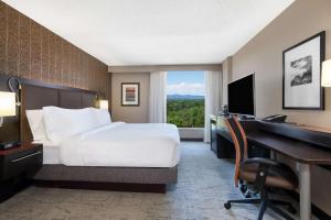 a hotel room with a bed and a desk and a computer at DoubleTree by Hilton Denver Cherry Creek, CO in Denver