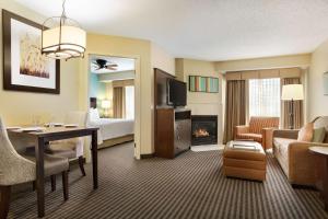um quarto de hotel com uma secretária e uma sala de estar em Homewood Suites by Hilton Houston-Willowbrook Mall em Houston
