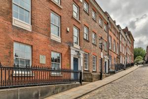 a brick building next to a cobblestone street at Paradise Square-Remodelled 18th Century Apartment in Sheffield