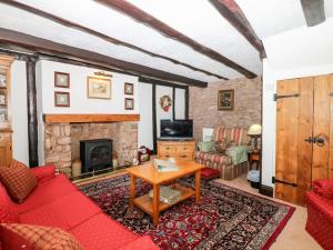 Una sala de estar con un sofá rojo y una chimenea. en Castle View, en Dunster