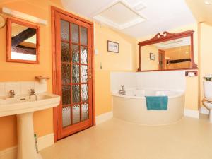 Un baño con bañera, lavabo y espejo. en Castle View, en Dunster 24 fotos más