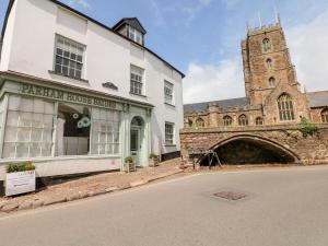 Un edificio blanco con una iglesia y una calle. en Castle View, en Dunster