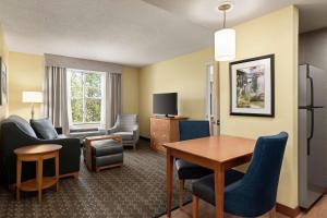 um quarto de hotel com uma mesa e cadeiras e uma sala de estar em Homewood Suites by Hilton Allentown-Bethlehem Airport em Bethlehem