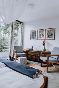 Kaliwa Lodge في موشي: غرفة نوم بسرير ومكتب وكراسي