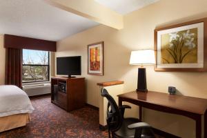 a hotel room with a desk and a bed and a desk and a television at Hampton Inn Houston Willowbrook Mall in Houston