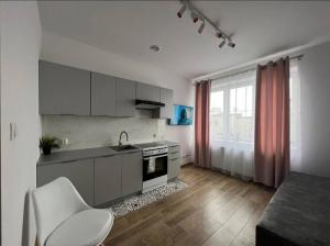 a kitchen with white cabinets and a table and a chair at Best for 2 in Pabianice