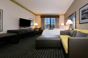 Hampton Inn & Suites San Francisco-Burlingame-Airport South في بورلينغامي: غرفه فندقيه بسرير واريكه وتلفزيون