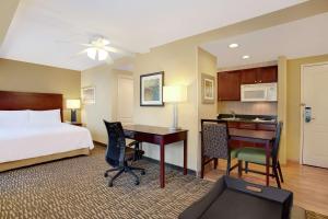 a hotel room with a bed and a desk and a computer at Homewood Suites by Hilton Tampa-Brandon in Tampa