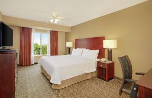 ein Hotelzimmer mit einem Bett und einem TV in der Unterkunft Homewood Suites by Hilton Tampa-Brandon in Tampa
