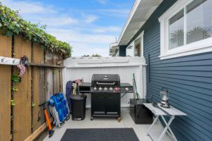 a backyard patio with a grill next to a house at Beach & Breezes in Huntington Beach