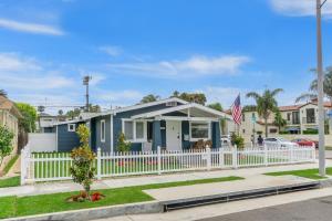 una casa azul con una valla blanca en Beach & Breezes, en Huntington Beach