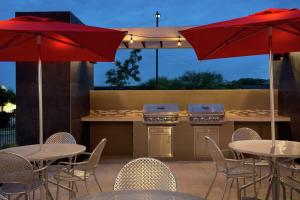 a patio with tables and umbrellas and a kitchen at Home2 Suites by Hilton San Antonio Airport, TX in San Antonio