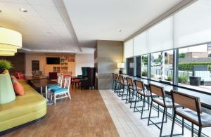 uma sala de espera com cadeiras e mesas e uma cafetaria em Home2 Suites by Hilton San Antonio Airport, TX em San Antonio