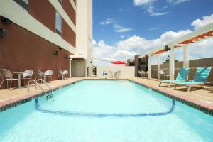 a swimming pool with chairs and a building at Home2 Suites by Hilton San Antonio Airport, TX in San Antonio