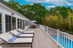 a deck with lounge chairs and a swimming pool at Southampton Beauty in Southampton