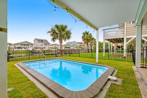 a swimming pool in a yard with a fence at The Blue Whale Inn in Ocean Isle Beach