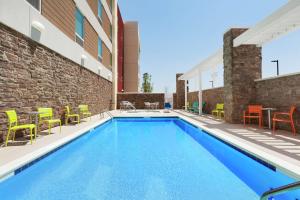 a swimming pool with chairs and tables on a building at Home2 Suites by Hilton San Angelo in San Angelo