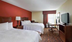 a hotel room with two beds and a flat screen tv at Hampton Inn Chicago-Tinley Park in Tinley Park