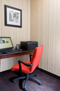 una sedia rossa seduta di fronte a una scrivania con computer portatile di Hampton Inn Chicago-Tinley Park a Tinley Park