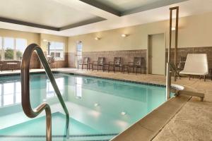 einen Pool mit Stühlen und Tischen in der Unterkunft Homewood Suites by Hilton Allentown-West/Fogelsville in Fogelsville