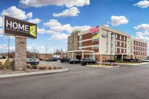 a sign for a hotel with cars parked in a parking lot at Home2 Suites By Hilton Olive Branch in Olive Branch