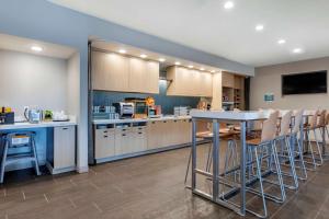 奥利夫布兰奇Home2 Suites By Hilton Olive Branch的一个带桌子和椅子的大厨房