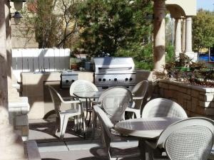 un patio al aire libre con mesas, sillas y una parrilla en Hampton Inn & Suites Albuquerque-Coors Road, en Albuquerque