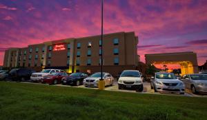 un estacionamiento con autos estacionados frente a un edificio en Hampton Inn & Suites Tomball, en Tomball