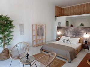 a bedroom with a bed and two chairs and a mirror at Maistrali in Provatas