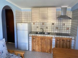 a kitchen with a white refrigerator and a sink at B&b brunos&brunos in Anzio