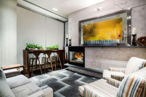 a living room with a fireplace and a tv at Hilton Garden Inn West 35th Street in New York