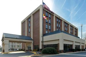 ein Hotelgebäude mit einer Flagge darüber in der Unterkunft Hampton Inn College Park in College Park