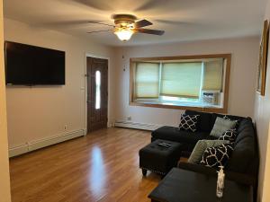 een woonkamer met een bank en een flatscreen-tv bij La Casita Bonita Near NYC in Yonkers