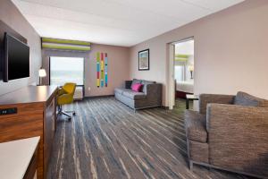 a living room with a couch and a tv at Hampton Inn College Park in College Park