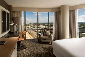 DoubleTree by Hilton Hotel Dallas Campbell Centre في دالاس: غرفة فندقية بسرير ونافذة كبيرة