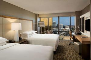 DoubleTree by Hilton Hotel Dallas Campbell Centre في دالاس: غرفة فندقية بسريرين ونافذة كبيرة
