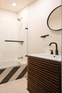 W łazience znajduje się umywalka, wanna i lustro. w obiekcie Beautiful & Stylish 2 BDR Hosted By StayRafa (1F) w Filadelfii