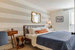 1 dormitorio con cama y espejo en la pared en Beautiful & Stylish 2 BDR Hosted By StayRafa (1F) en Filadelfia
