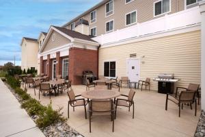 a patio with tables and chairs in front of a building at Homewood Suites Atlantic City Egg Harbor Township in Egg Harbor Township