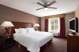 a bedroom with a large white bed and a flat screen tv at Homewood Suites Atlantic City Egg Harbor Township in Egg Harbor Township