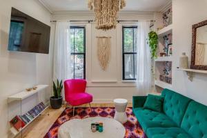 uma sala de estar com um sofá verde e uma cadeira vermelha em Beautiful & Stylish 2 BDR Hosted By StayRafa (1F) em Filadélfia