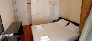 1 dormitorio pequeño con 1 cama con 2 almohadas blancas en Paradeisos, en Atenas